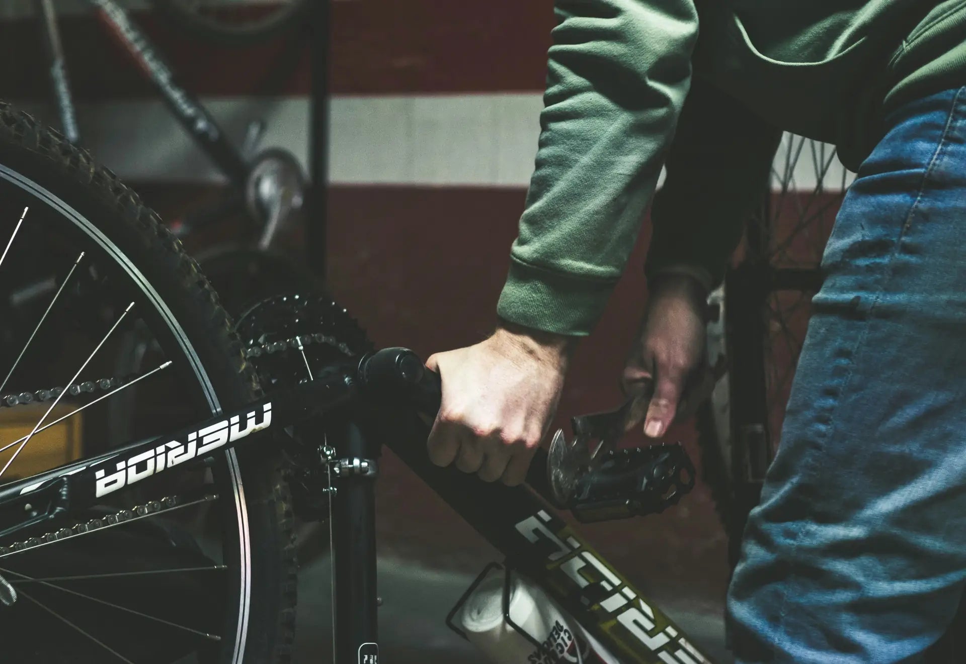 A mechanic servicing a mountain bike on a workshop stand